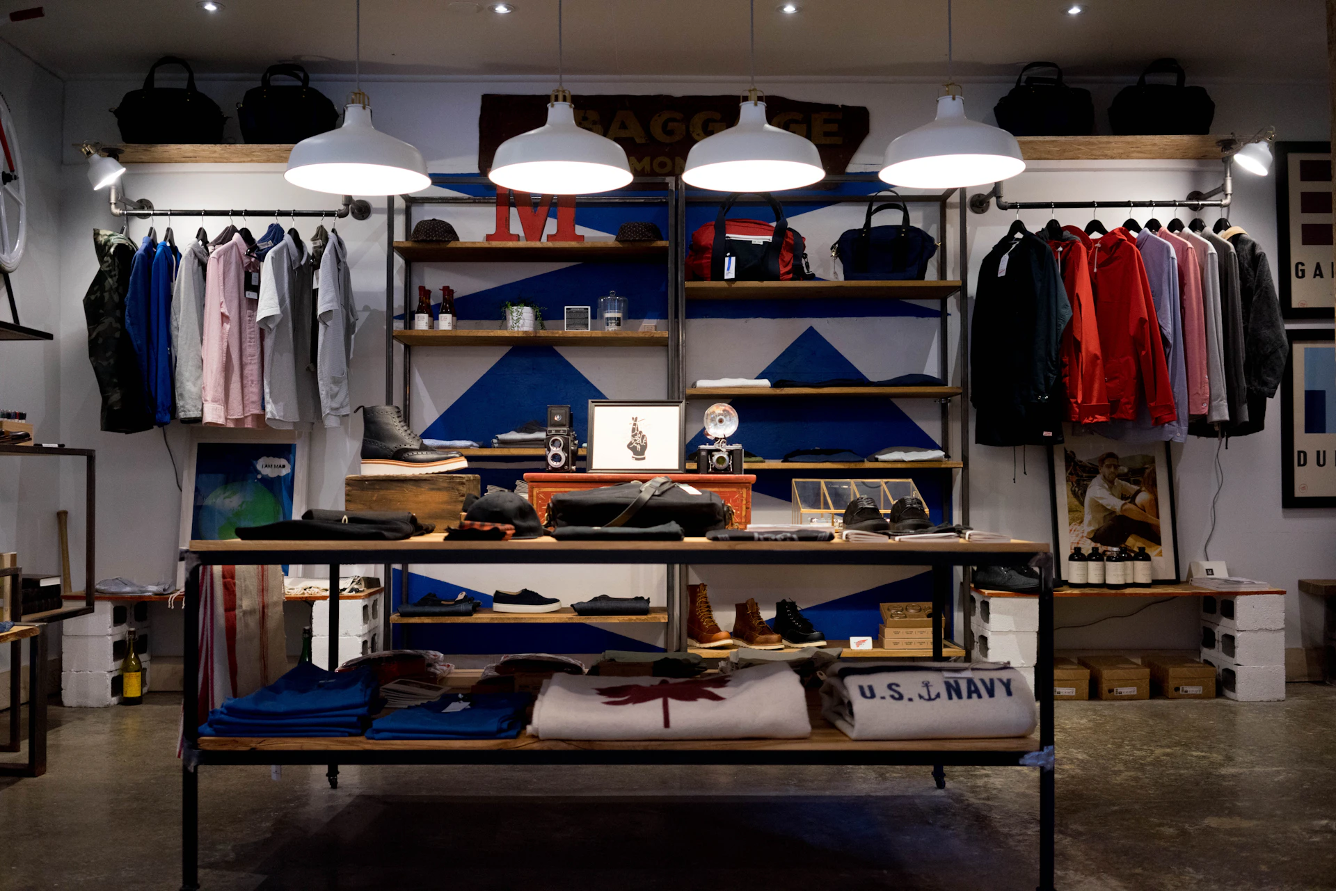 Timber and steel displays beneath white pendant lights at Clark Street Mercantile — reference photograph