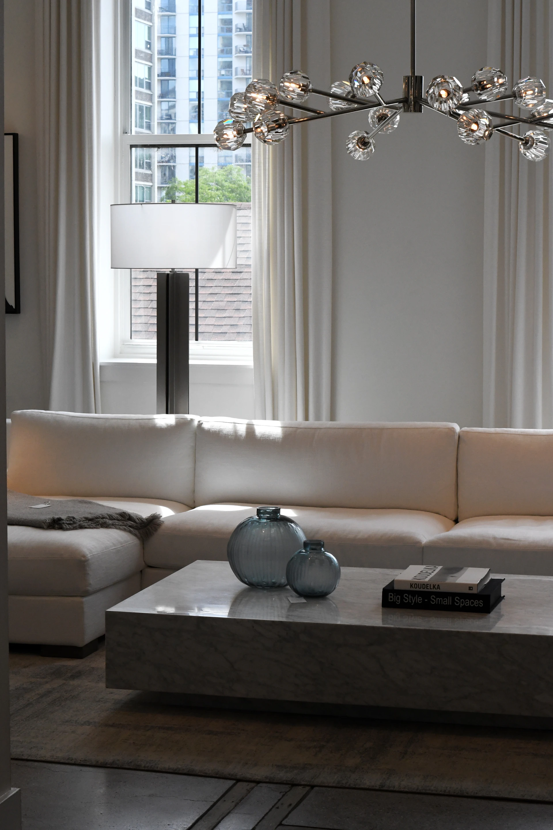 Natural light, glass lighting, and soft upholstery in a calm interior