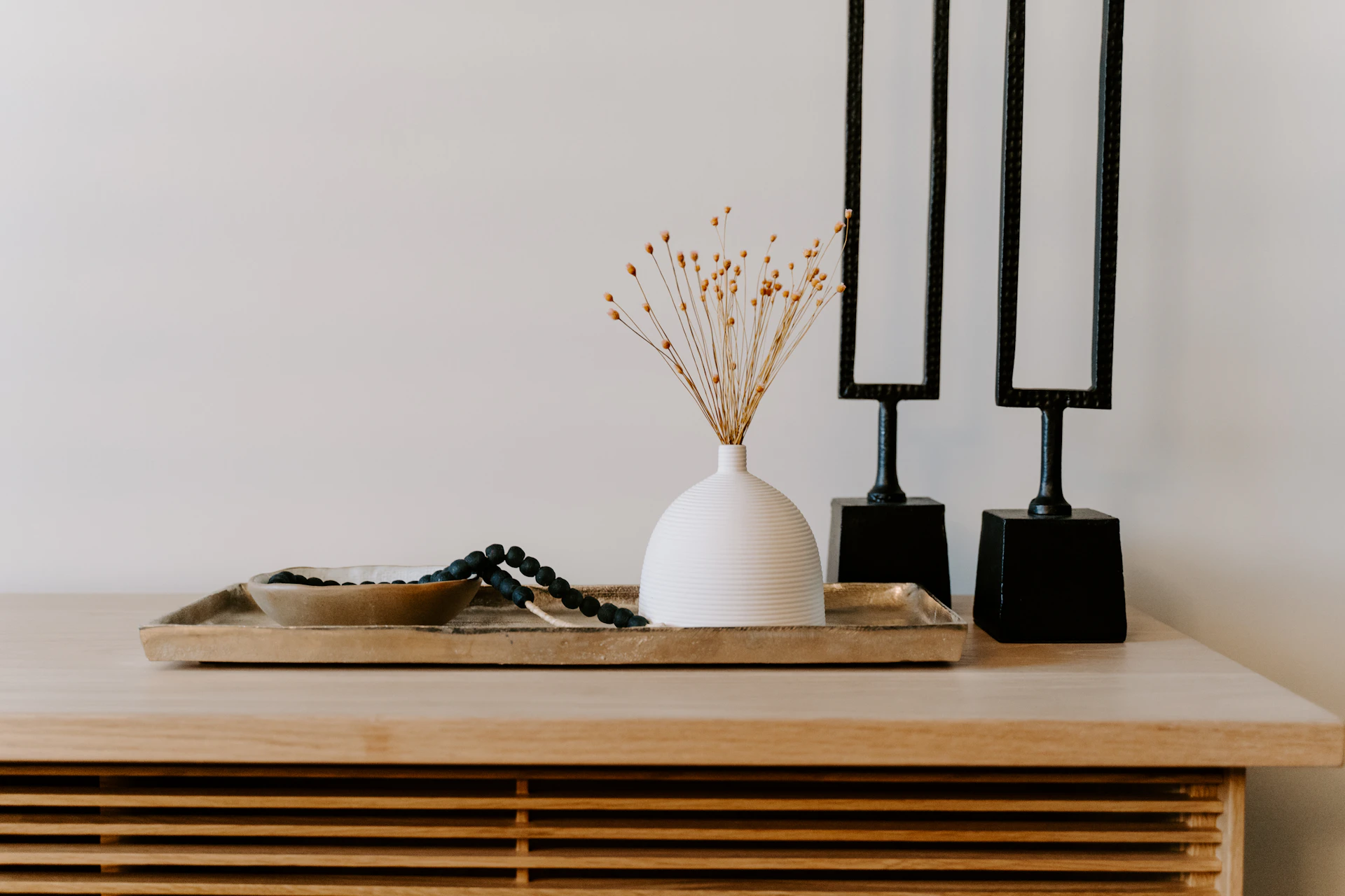Ceramic and sculptural objects arranged on a warm timber console